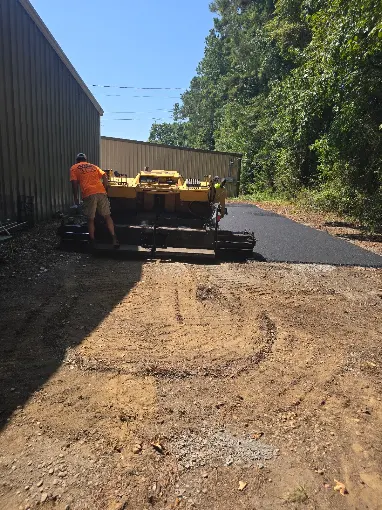Southern Blacktop Solutions crew laying and rolling hot asphalt on a new driveway in Prattville, Alabama